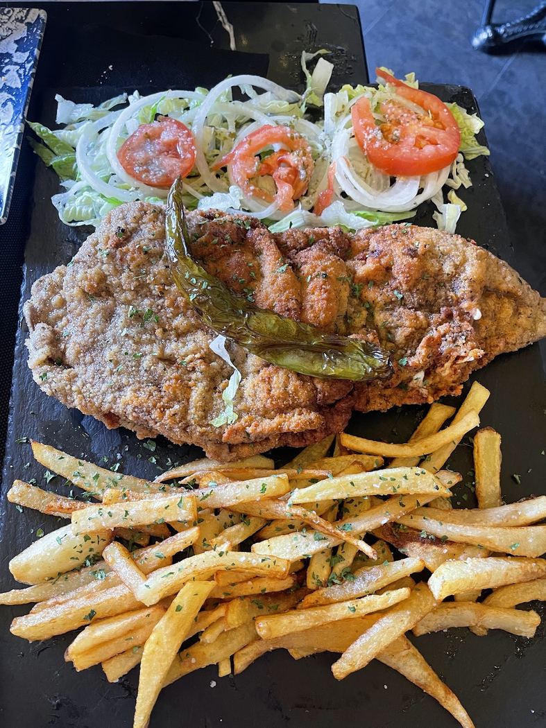 Escalope San Isidro. Ternera empanada con patatas fritas caseras y ensalada fresca.